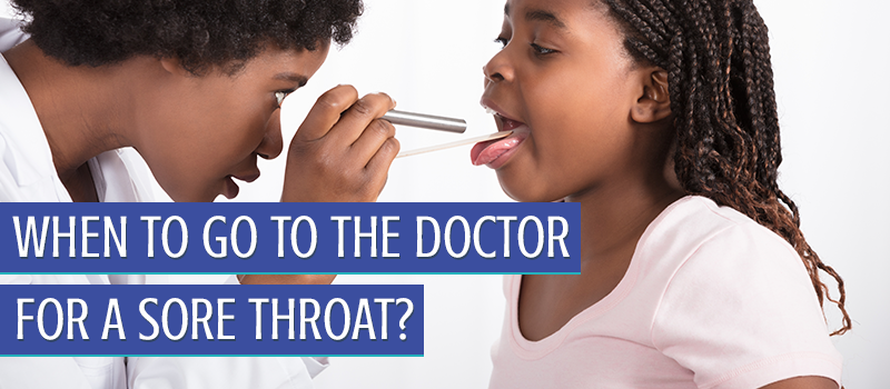 Pediatrician checking young girl's throat