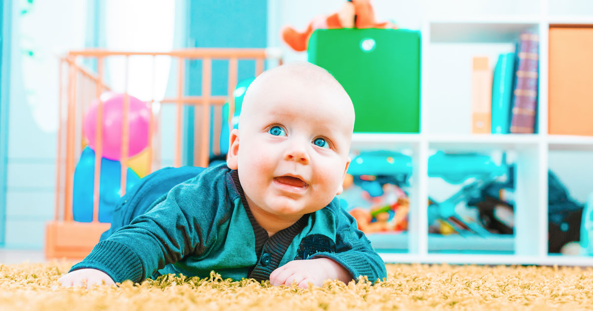 baby crawling on carpeted ground in bedroom