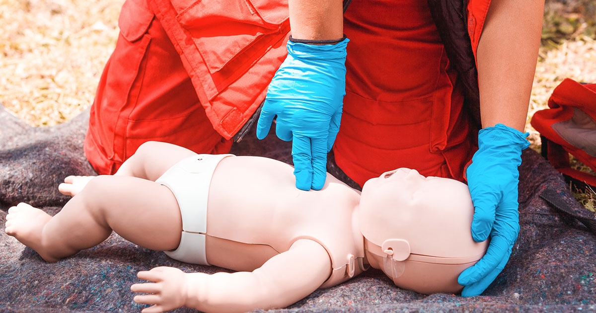 performing CPR on a baby doll