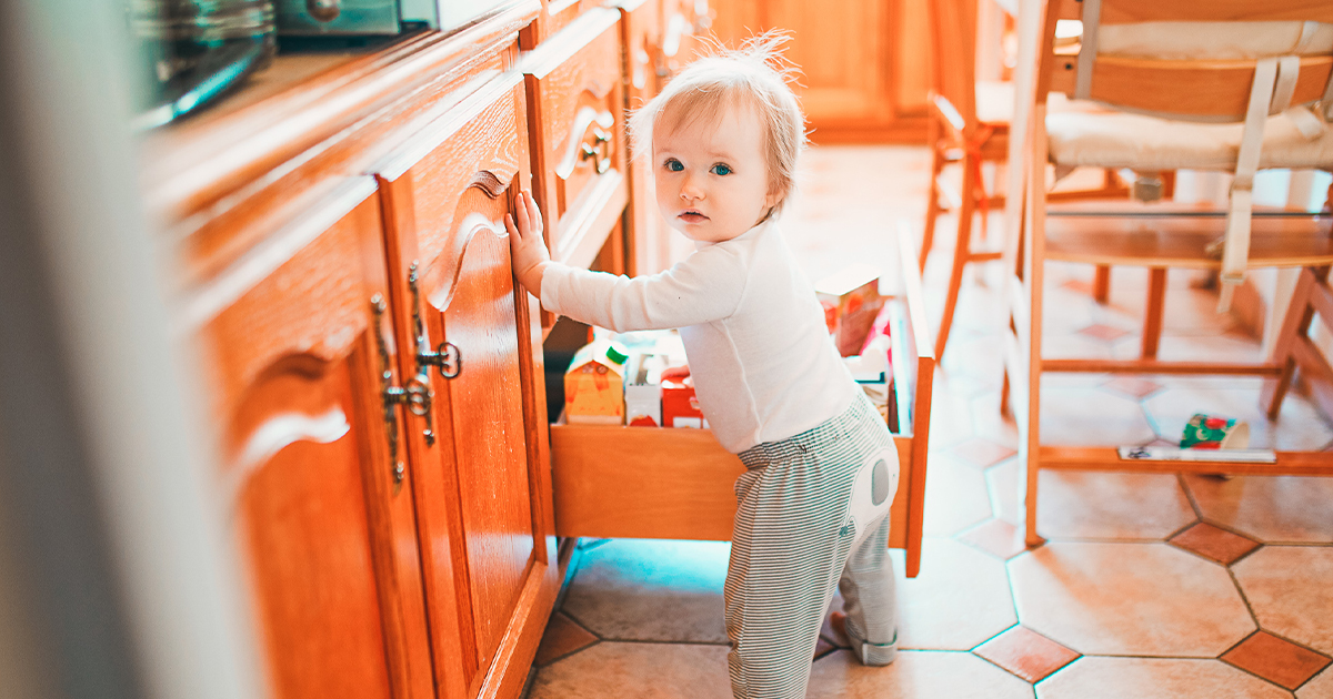 baby trying to get into kitchen cabinet