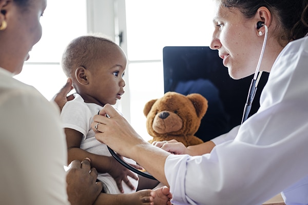 Doctor using stethoscope on child